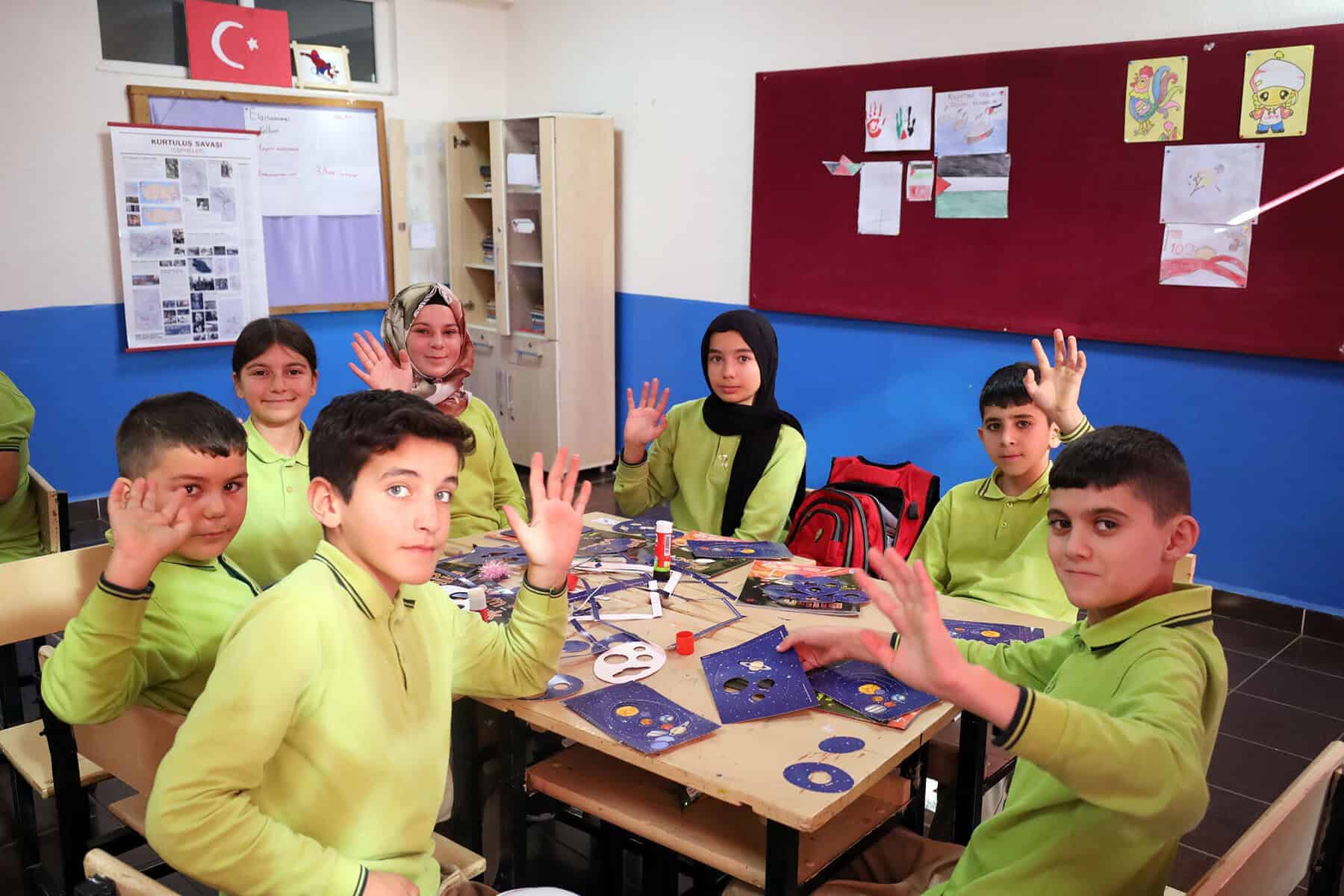 Türk bayrağı ve eğitim ortamında çocuklar projelerle uzay temalı faaliyetler yapıyor.